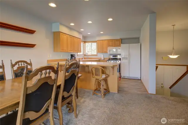 The open concept floor plan flows into the dining space, and the kitchen that also has eating space at the bar.