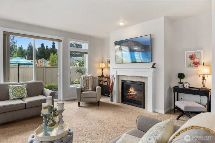 This comfortable living room has a cozy gas fireplace and access to a fully fenced and private back yard.