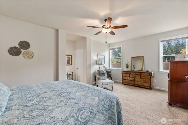The space easily accommodates a king-size bed with room to spare for a cozy sitting area and a stylish dresser or console. A doorway leads directly to the en-suite bathroom, providing added privacy and convenience.