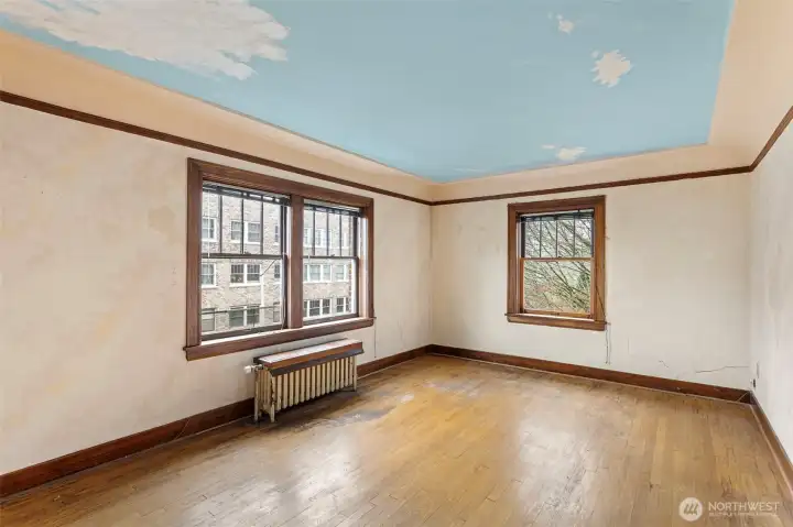 Vintage charm abounds in the living room, with coved ceilings, oak floors, divided-light windows, and generous proportions. The oak floors are well loved but in solid shape, just waiting for a fresh refinish to bring back their original old-growth glow.