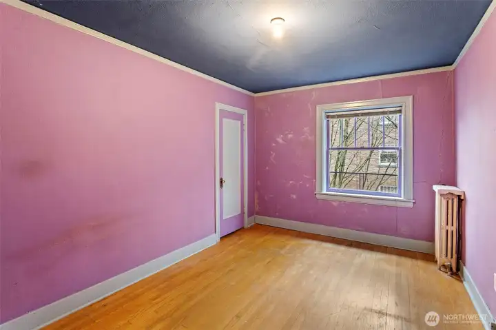 Wake up to courtyard views in this spacious bedroom—complete with a walk-in closet and ready for a bold refresh or your next color story.