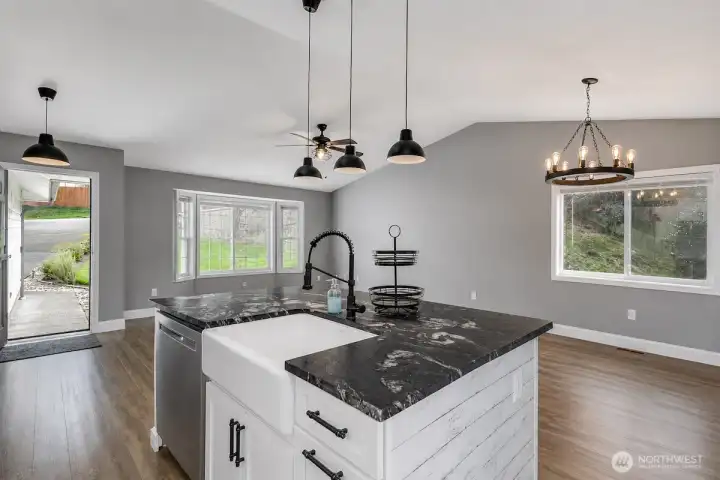 This AI generated photo demonstrates the view from the kitchen to the living room and dining room with no furniture. Sellers have just move their furniture from the home.