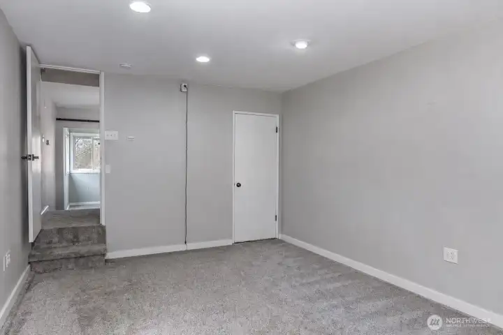 This AI generated photo demonstrates part of the family room downstairs with no furniture. Sellers have just move their furniture from the home.