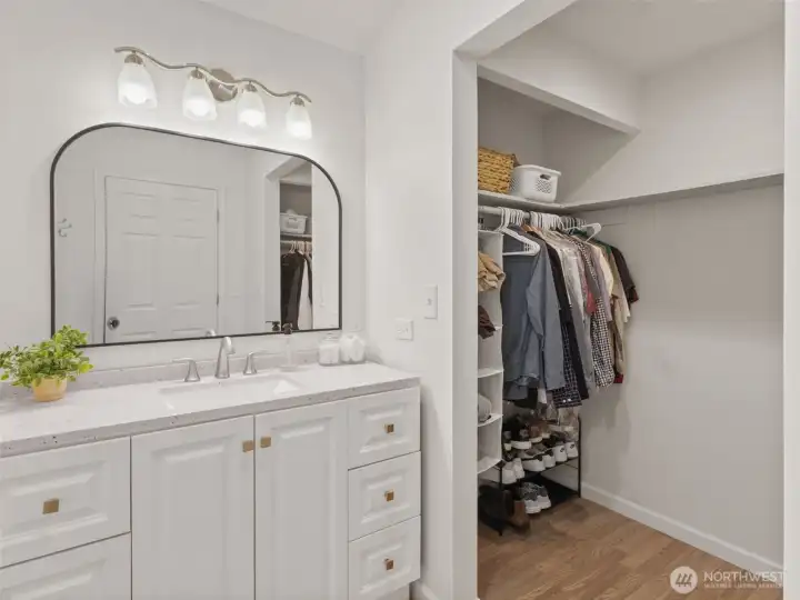 Primary bathroom vanity looking toward walk-in closet.