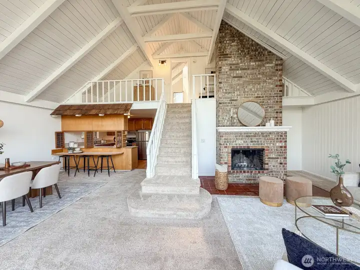Full view of the room with cathedral ceilings and stairway to loft area
