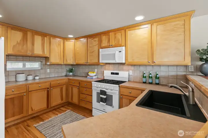 The kitchen is oversized for a townhome... Notice the extensive counterspace and tons of storage. Notice the newly refinished hardwood floors