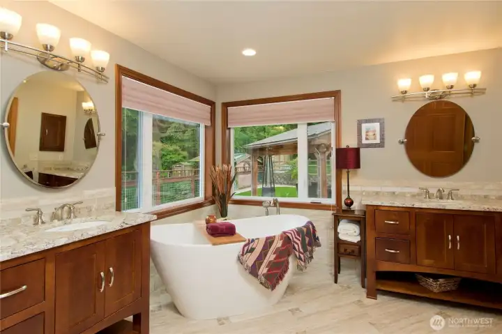 Luxurious bathroom connected to primary bedroom with his & hers sinks, tiled & heated floors, tiled shower, and walk in closet.