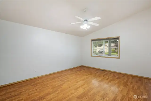 Formal living area has vaulted ceilings and laminate flooring.