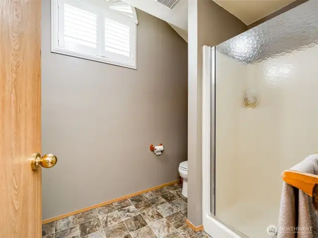 Light and bright primary ensuite with shower and plantation shutters.