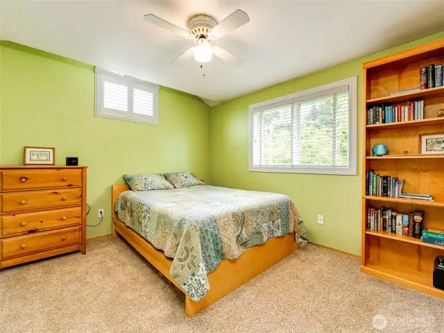 Spacious bedroom with plantation shutters and wall-to-wall carpet.
