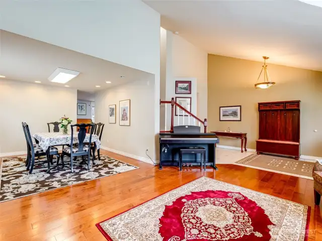 Open living room leading into the formal dining room with hardwood floors.