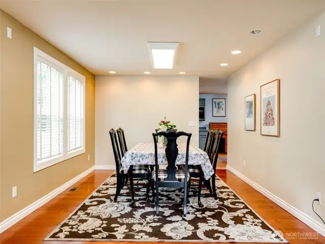Formal dining room with hardwood floors leading to kitchen.