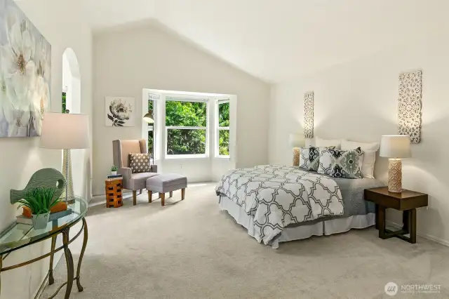 Large primary suite with vaulted ceiling , arched doorway and big walk in closet.