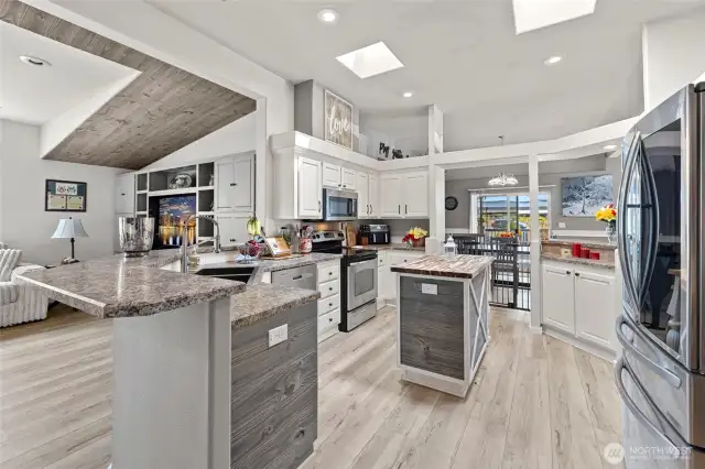 Light, bright, beautiful open floor plan circular chef's kitchen with stainless appliances and family room