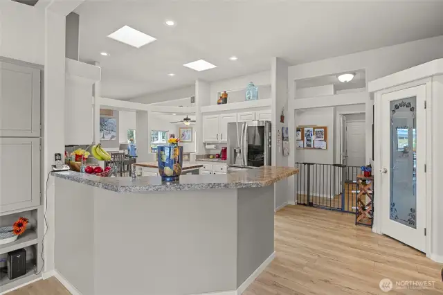 Chef's kitchen with granite countertops, stainless appliances, skylights, and large pantry
