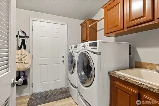 Laundry room with large capacity HE washer/dryer, utility sink, storage