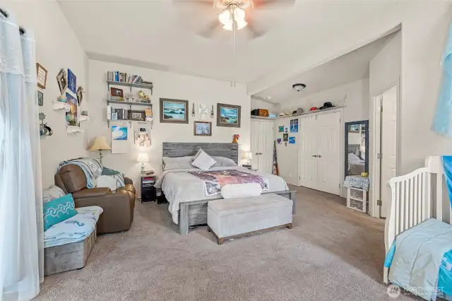 Large primary bedroom with large walk-in closet, large en-suite bathroom attached, sliding glass doors to back deck
