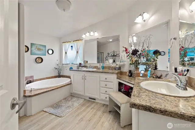 Primary en-suite bathroom with double sinks, soaking tub, shower and extra storage space