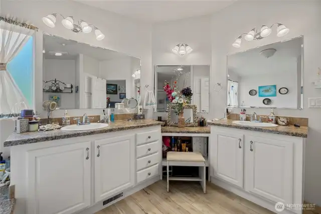 Primary en-suite bathroom with double sinks, soaking tub, shower and extra storage space