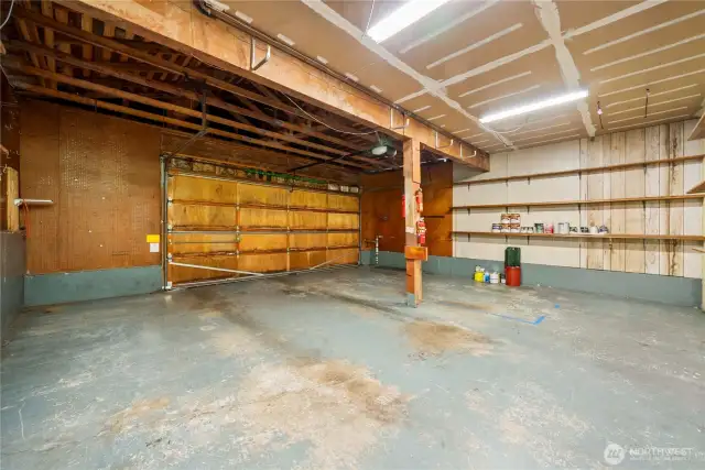 Large 2 car garage with additional storage space & shelves.