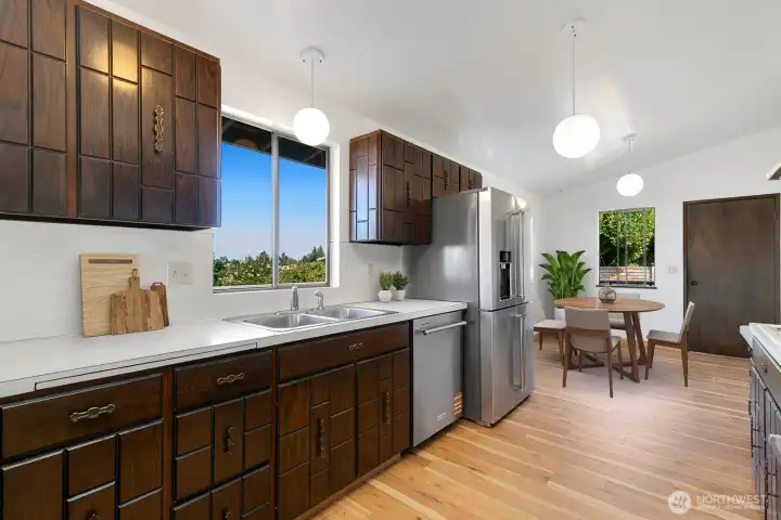 Kitchen has solid wood cabinets, new stainless steel dishwasher, french door fridge, and microwave/range hood. There is an eating nook and door to the deck and back yard.