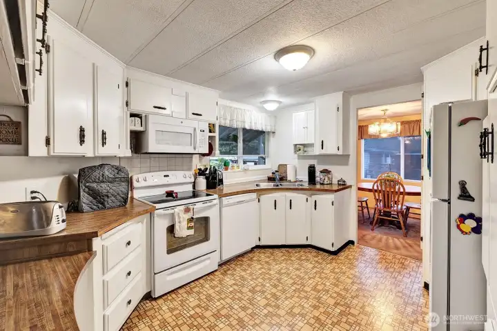 Large, circular style kitchen. All white-on-white appliances included in sale. Butcher block counter tops. Plenty of prep and storage space. Garden window brings in natural light and gives you a view of outside area.