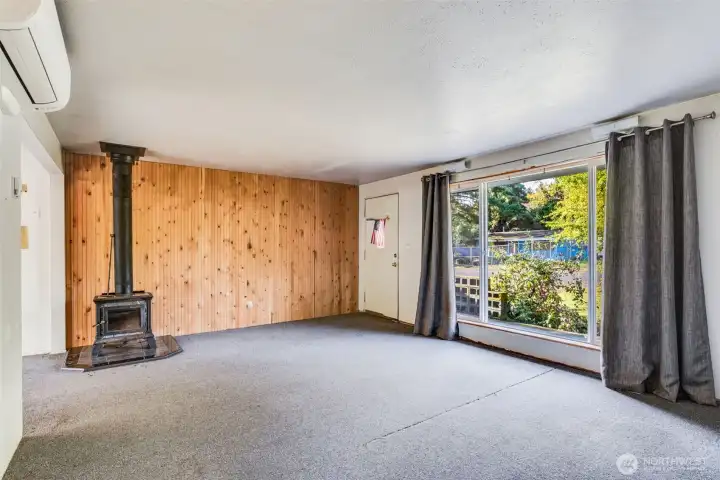 Large living room has a cozy wood fireplace.