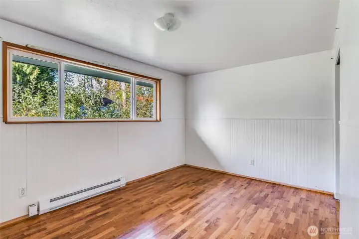 The second bedroom has a large window that looks out towards the front yard.