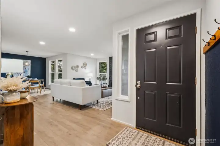 The open-concept living room features new LVP flooring and a striking accent fireplace wall. It’s the perfect space to relax, unwind, and entertain with ease.