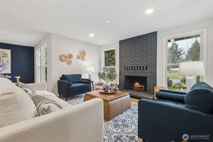 The beautifully accented fireplace—with windows on each side—creates a balanced, eye-catching focal point that transforms the entire room. Sunlight filters in throughout the day, bringing an airy brightness that complements the home’s modern updates.