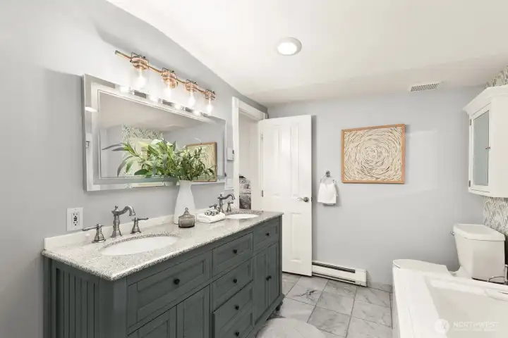 Updated primary bathroom with dual sinks, a jetted tub and a large shower for two!