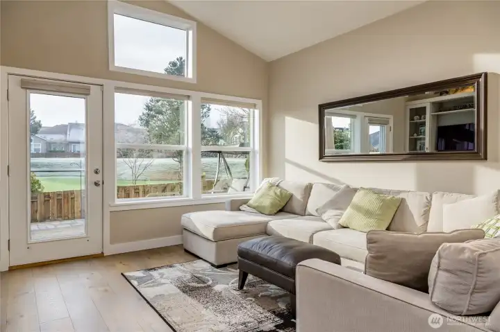 The bright and airy living space offers a peaceful perspective, directly overlooking the community putting green