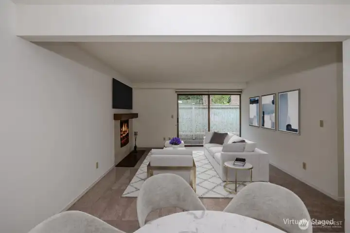 Living space with easy access to the back patio and wood-burning fireplace (virtual staging)