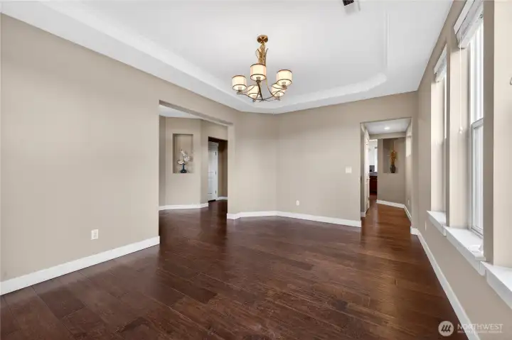 Spacious formal dining room showcases a coved ceiling, hardwood flooring, and a convenient butler’s pantry with easy access to the kitchen—perfect for entertaining.