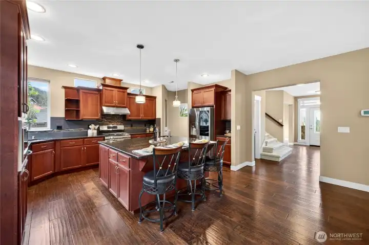Chef’s kitchen features stainless steel appliances, granite countertops, tile backsplash, a large pantry, and an abundance of cabinet and counter space. The oversized island provides impressive prep space and casual dining.