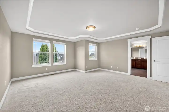 Luxurious primary suite features a coved ceiling, beautiful morning and evening views, a private ensuite bath, and a spacious walk-in closet.