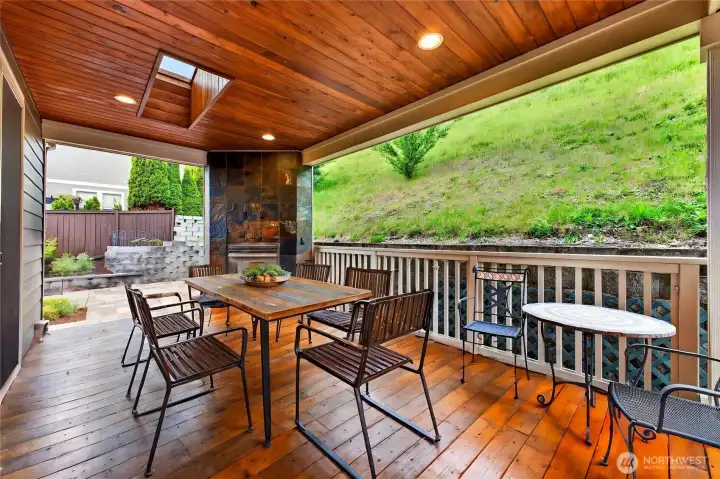 Private covered deck is an inviting outdoor retreat featuring a skylight, gas fireplace, and built-in lighting—perfect for relaxing evenings or year-round entertaining.
