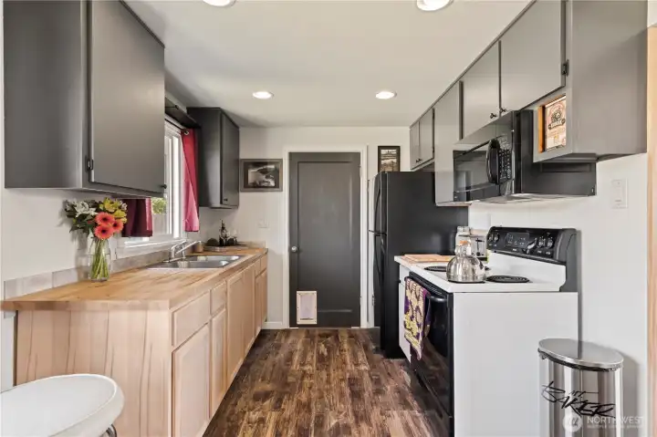 Galley style kitchen with tastefully updated lower cupboards and butcher block counter tops. Galley style kitchen with tastefully updated lower cupboards and butcher block counter tops.