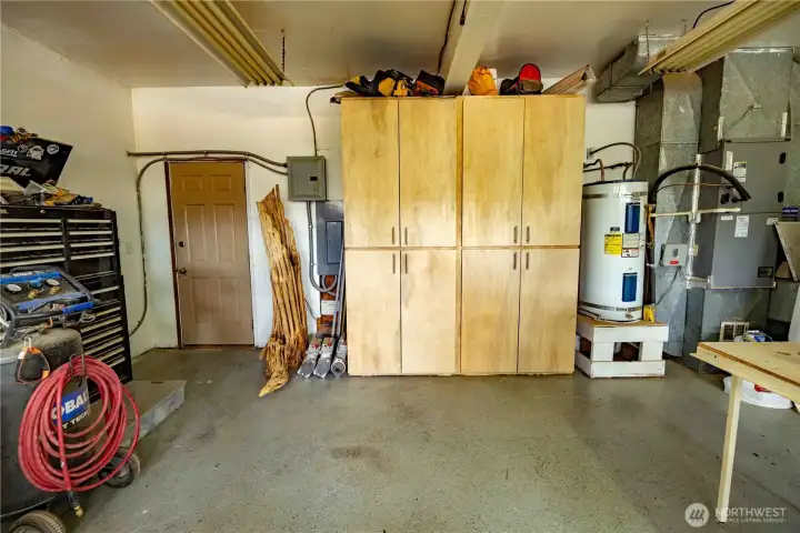 Deep garage with built in cabinetry and workspace Deep garage with built in cabinetry and workspace