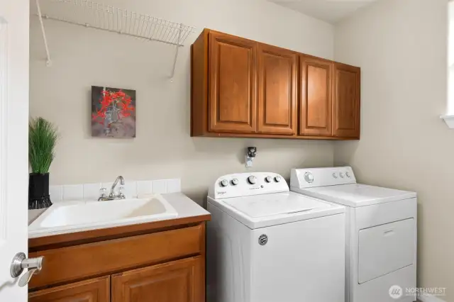 Laundry with custom cabinets and a sink.