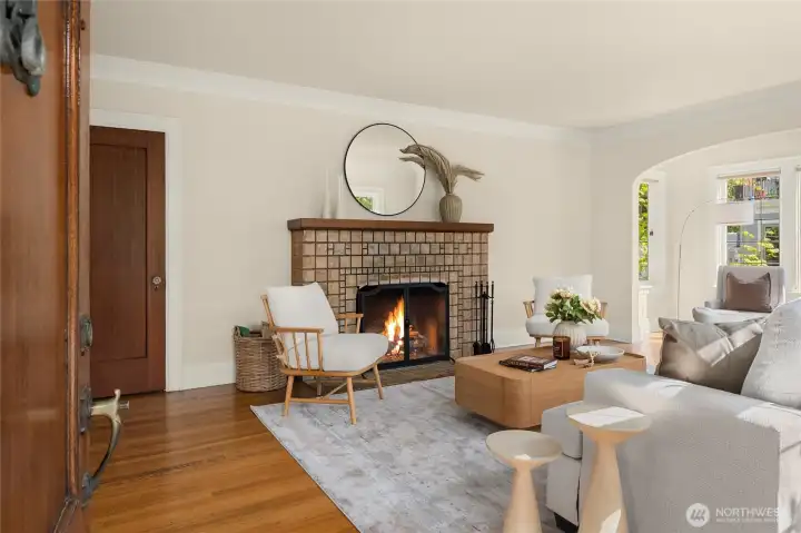 As you enter the home...Beautiful tiled wood burning fireplace, coved archways and walls of divided light windows flood this home with sunshine!
