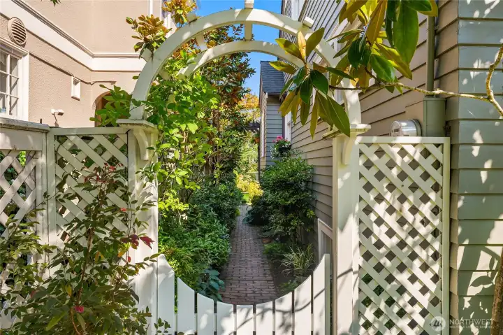 This gate is to the side of the front patio and via a charming brick pathway...leads to the back garden and the deck off of the kitchen.