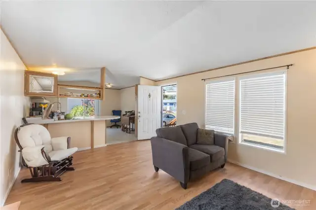 The living space with laminate floors looking through to the kitchen