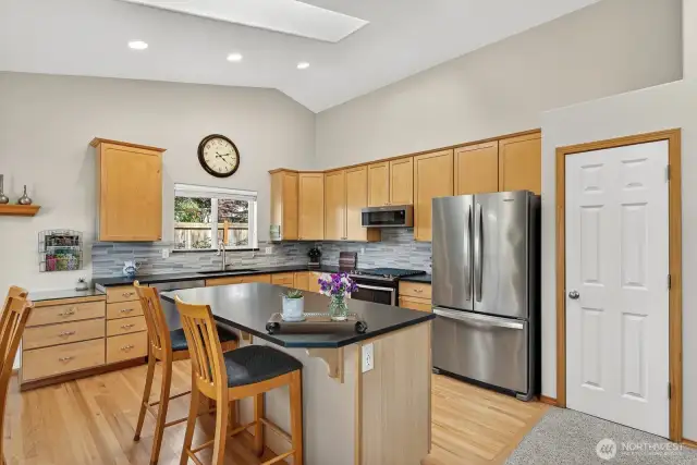 Beautiful kitchen with custom tile back splash, honed granite counters & island. Stainless steel appliances, pantry and lots of cabinet & drawer space. More of the hardwood floors. Gas stove along with gas dryer.