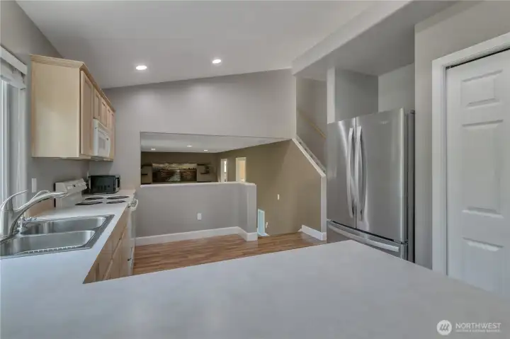 View from breakfast bar through kitchen to family room. Screen added to opening for easy darkening of the family/media room when watching movies on the 70" TV. (TV can be purchased separately from seller).