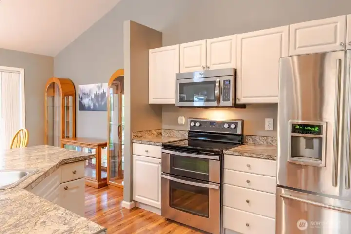 Updated kitchen with stainless steel appliances including a double oven.