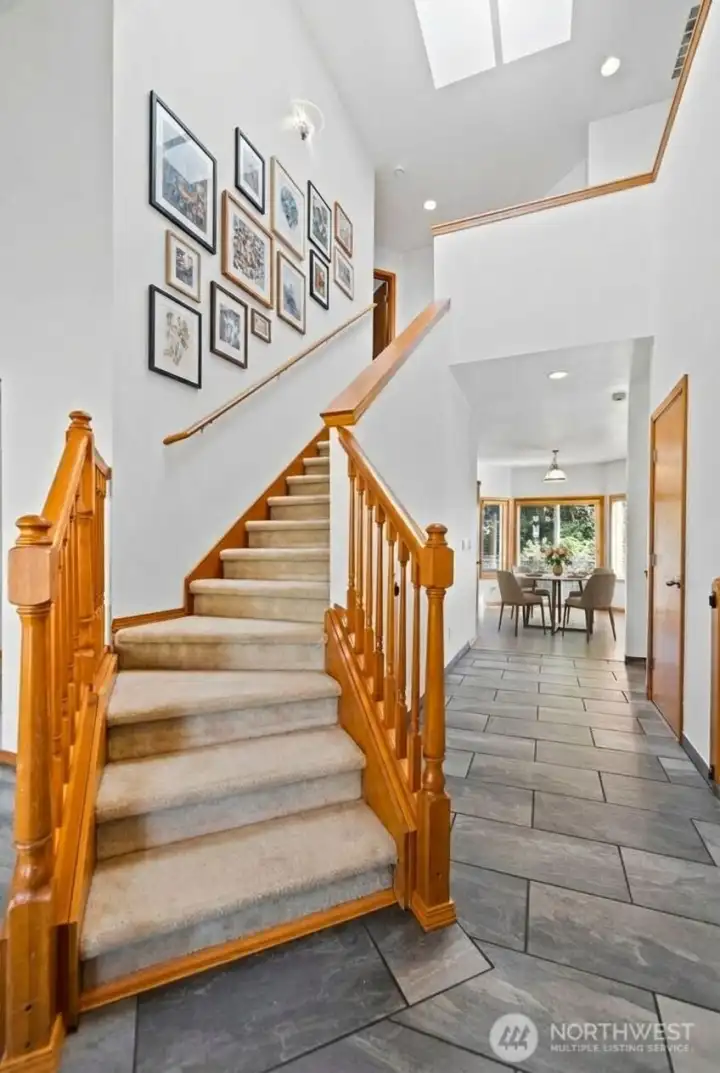 Tall ceilings, stairs leading to the second floor and new tile greet you as you step inside. (photo virtually staged)