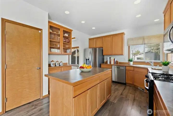 Make your way into the light-filled kitchen with an oversized pantry with shelving,  and newer refridgerator & dishwasher. (photo virtually staged)