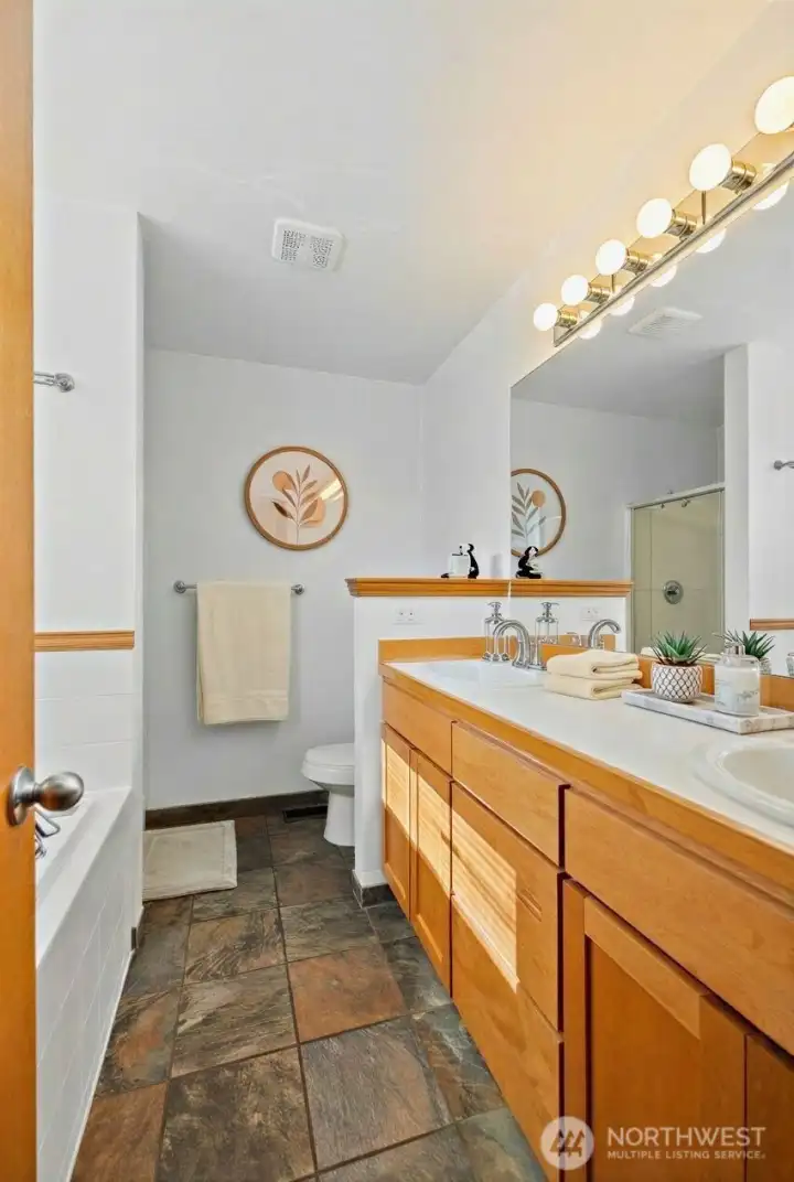 Primary bathroom includes soaking tub and double sinks. (photo viturally staged)