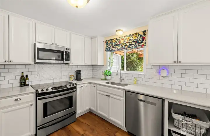 Stainless appliances, quartz counters and tiled backsplash.